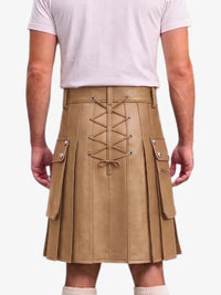 A person shown from the back wearing a tan pleated faux-leather kilt with a lace-up front, side cargo pockets, and silver-tone hardware, paired with a light pink t-shirt.