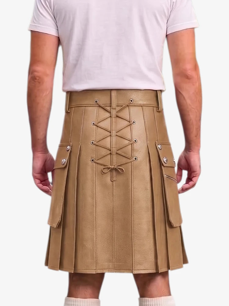A person shown from the back wearing a tan pleated faux-leather kilt with a lace-up front, side cargo pockets, and silver-tone hardware, paired with a light pink t-shirt.