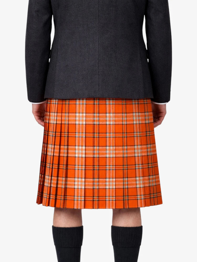 Person wearing a black jacket and orange plaid kilt on a white background