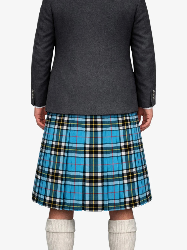 Person wearing a gray blazer and blue plaid kilt on a white background
