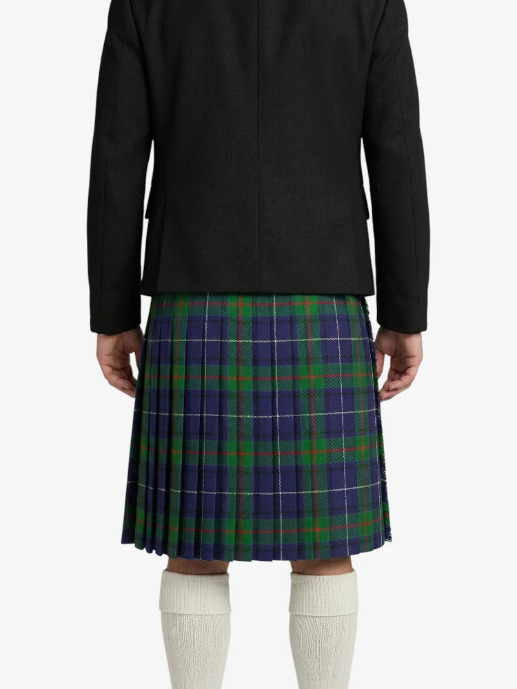 Person wearing a black jacket and plaid kilt on a white background