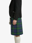 Person wearing a black blazer and a green plaid kilt on a white background
