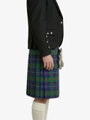 Person wearing a black blazer and a green plaid kilt on a white background