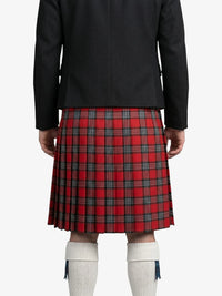 Person wearing a black jacket and red plaid kilt on a white background