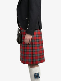 Person wearing a black jacket and red plaid kilt on a white background