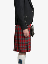 Person wearing a black jacket and red plaid kilt on a white background