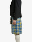 Person wearing a black jacket and blue and yellow plaid kilt on a white background