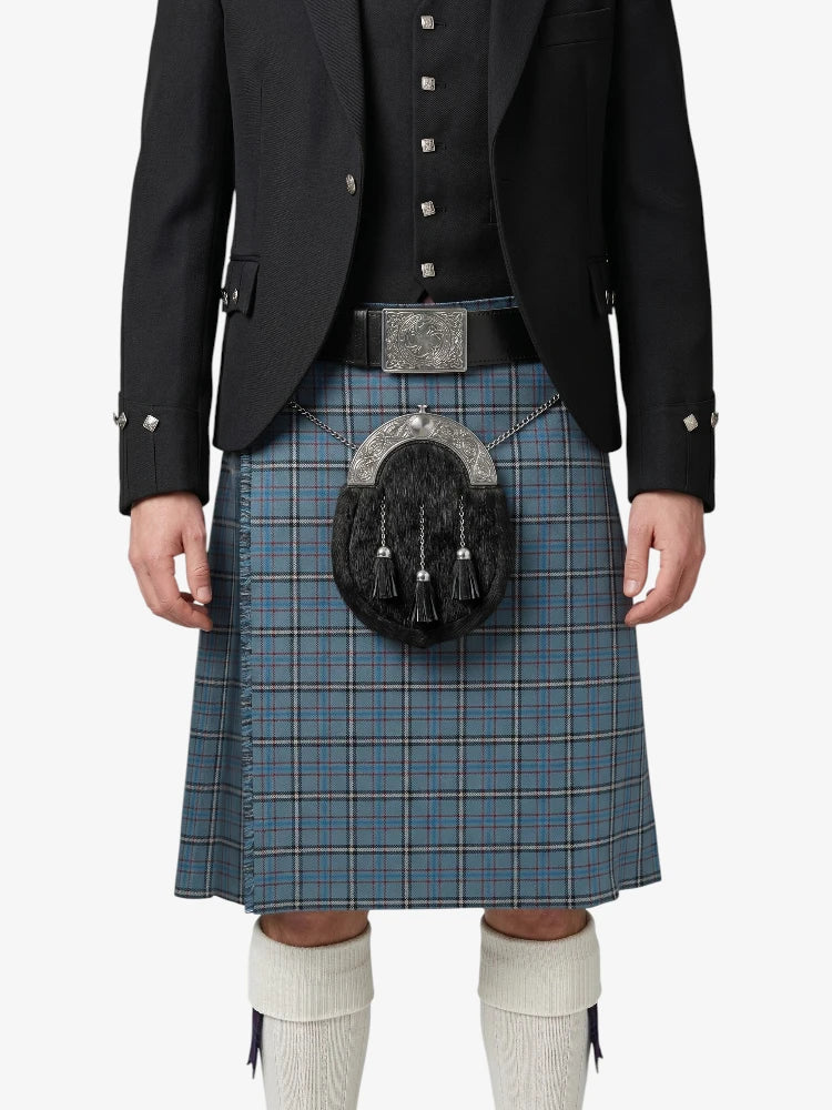 Person wearing a traditional Scottish kilt with a jacket on a white background