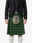 Person wearing a green plaid kilt with a black jacket and white socks on a white background