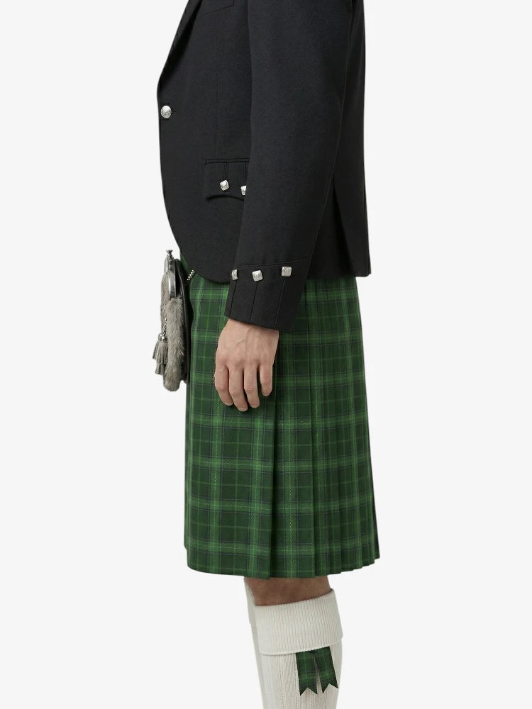 Person wearing a black jacket and green plaid kilt on a white background
