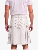 A person shown from the back wearing a pleated kilt with front lace-up detailing and side cargo pockets, paired with a light pink t-shirt and white socks against a plain light background.