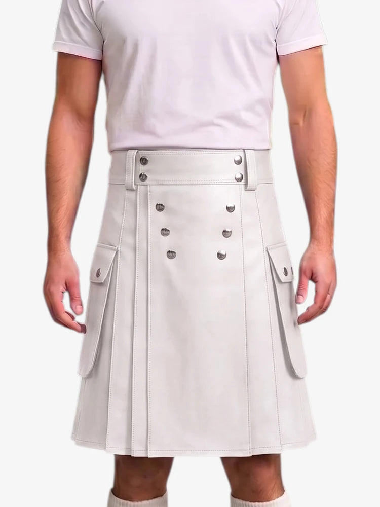A person wearing a light gray pleated faux-leather kilt with double-breasted silver buttons and side flap pockets, paired with a pale pink t-shirt against a light gray background.