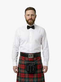 Man wearing a white shirt, black bow tie, and red plaid kilt on a white background