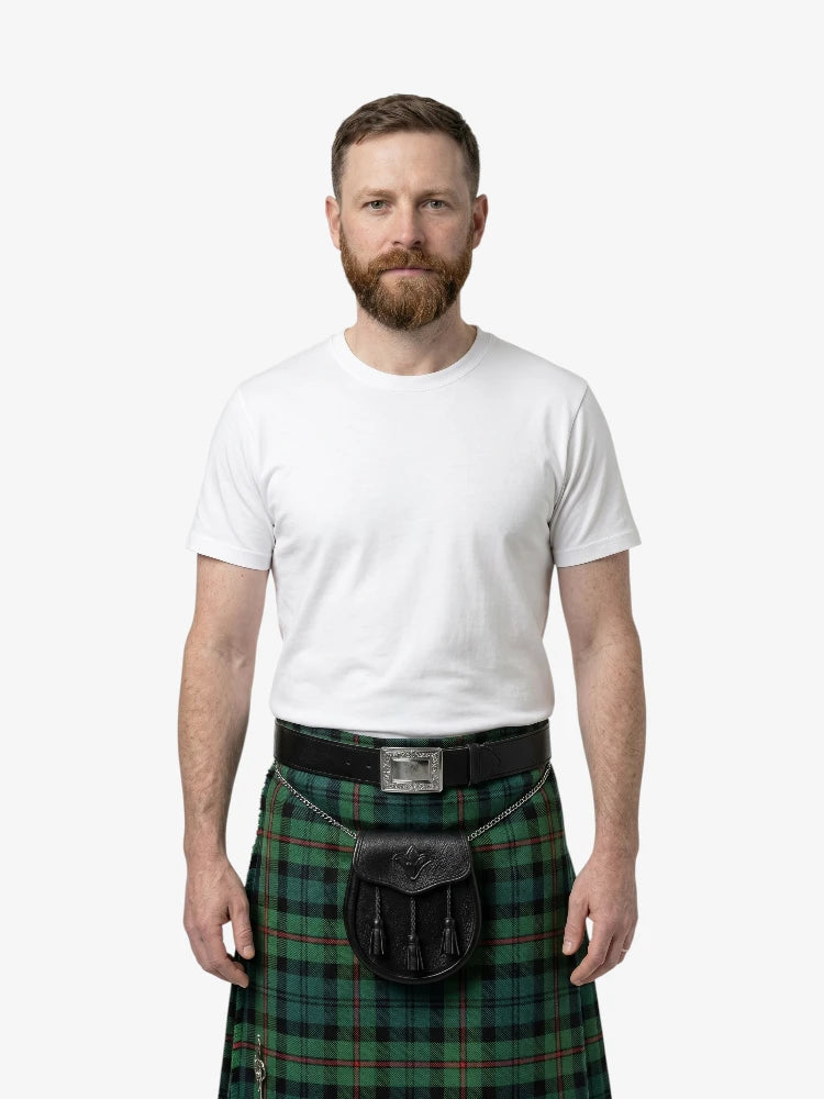 Man wearing a green plaid kilt with a white shirt on a white background