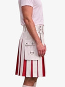 A side view of a person wearing a white kilt with red vertical pleated stripes and silver metal hardware, paired with a white t-shirt, against a plain light gray background.