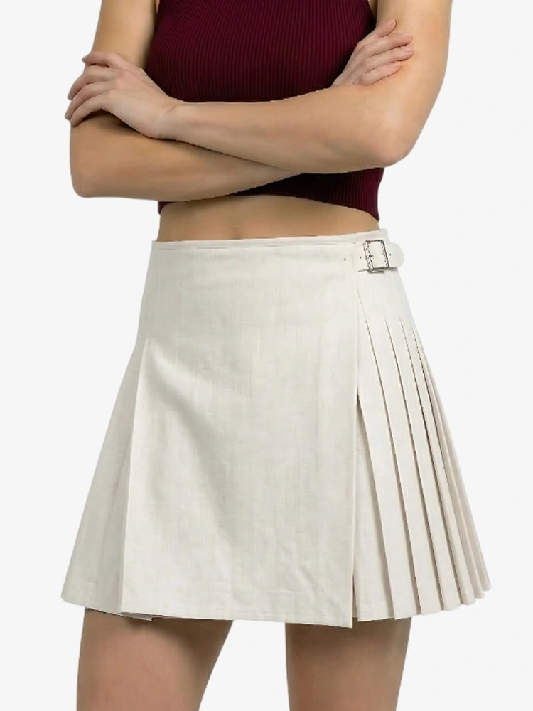 Person wearing a white pleated skirt with a belt on a white background