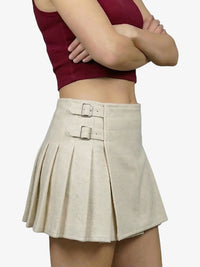 Beige pleated skirt worn by a person on a white background