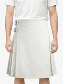 Person wearing a white skirt with silver buckles on a plain background