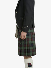 Person wearing a black jacket and green plaid kilt on a white background