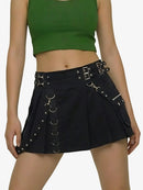 Person wearing a green crop top and black skirt with metal accents on a white background