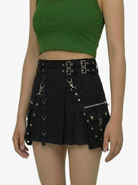 Person wearing a green crop top and black skirt with metal accents on a white background