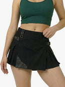 Person wearing a green crop top and black skirt with leather accents on a white background