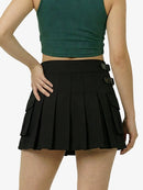 Person wearing a green crop top and black pleated skirt on a white background