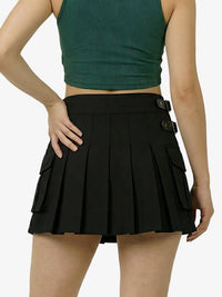 Person wearing a green crop top and black pleated skirt on a white background
