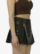 Black skirt with chain details worn by a person on a white background
