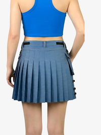 Person wearing a blue pleated skirt and blue crop top on a white background