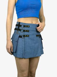 Person wearing a blue skirt with black belt and hardware on a white background