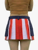 Person wearing a red, white, and blue striped skirt with navy accents on a plain background