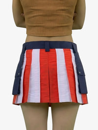 Person wearing a red, white, and blue striped skirt with navy accents on a plain background