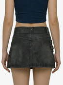 Person wearing a black denim skirt with cargo pockets on a white background