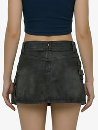Person wearing a black denim skirt with cargo pockets on a white background