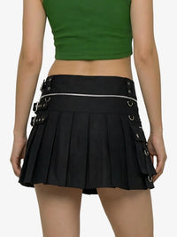 Person wearing a green crop top and black pleated skirt with buckles on a white background