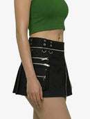 Black skirt with zippers and grommets worn by a person on a white background