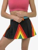 Person wearing a pink crop top and a black skirt with a rainbow pattern on a white background