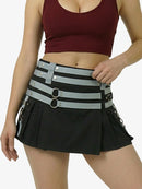 Black skirt with gray straps and silver buckles worn by a person on a white background