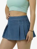 Person wearing a blue pleated skirt and light green crop top on a white background