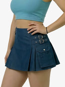 Person wearing a blue top and navy skirt with buckles on a plain background