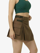 Person wearing a green crop top and brown cargo skirt on a white background