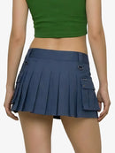Person wearing a green crop top and blue pleated skirt on a white background