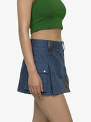 Person wearing a blue skirt with a green top on a white background