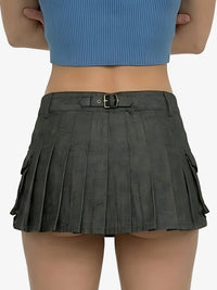 Person wearing a gray pleated skirt with a blue top on a white background