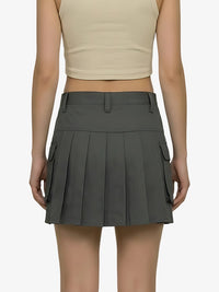 Person wearing a gray pleated skirt with pockets on a white background