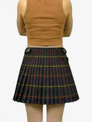Person wearing a plaid skirt and beige top on a white background