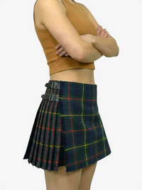 Person wearing a green plaid skirt with a plain background