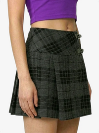 Person wearing a black plaid skirt with a purple top on a white background