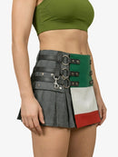 Person wearing a green sports bra and a unique skirt with leather straps and color-block design on a white background.